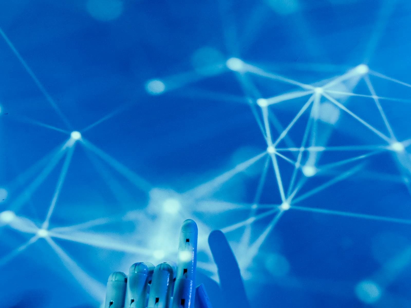 Mano robótica conectada a una red de nodos que representa inteligencia artificial.